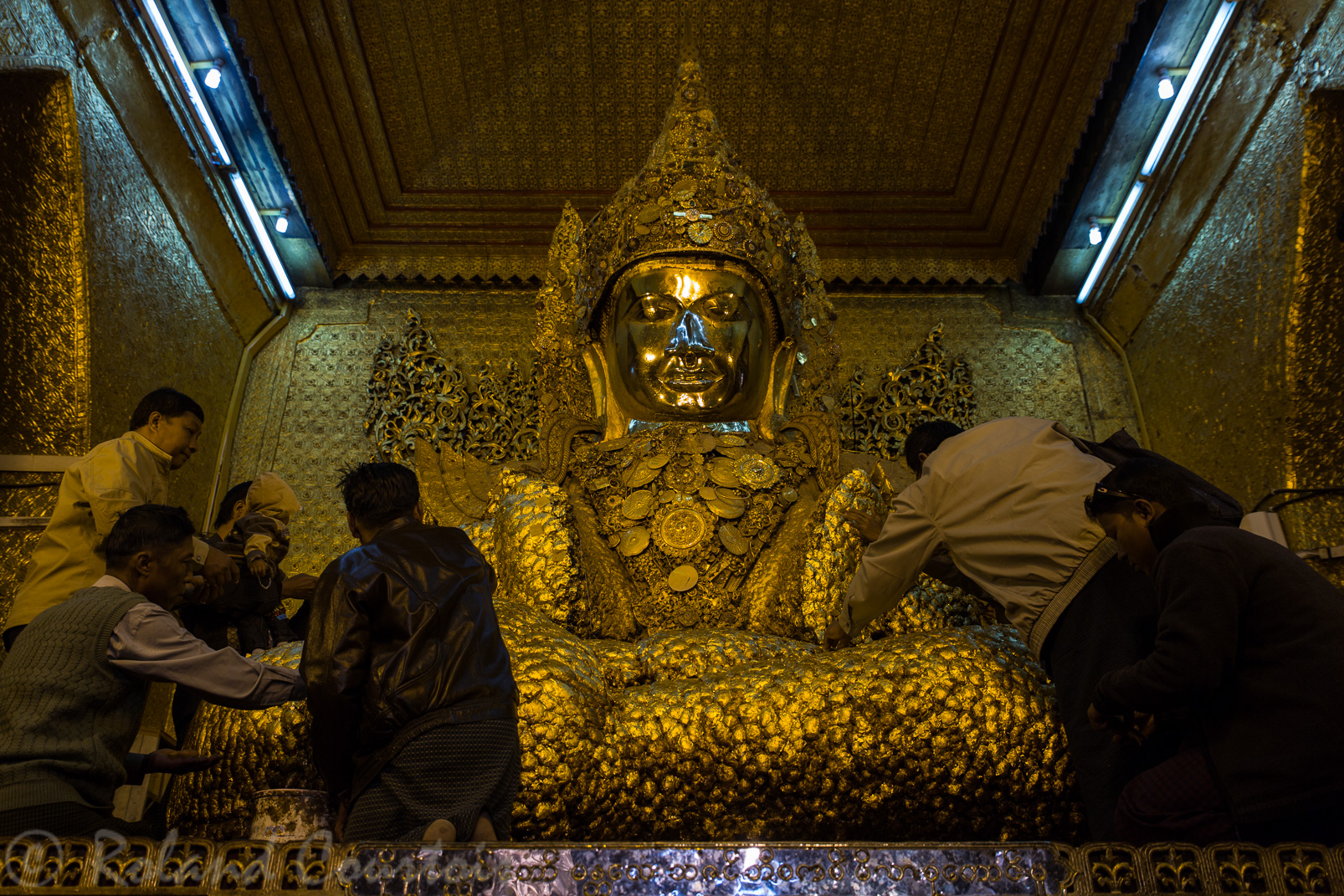 La Pagode Maha Muni protège un grand Bouddha arakanais couvert de feuilles d'or. Seuls les hommes défilent devant ce Bouddha très ancien pour y coller des feuilles d’or.